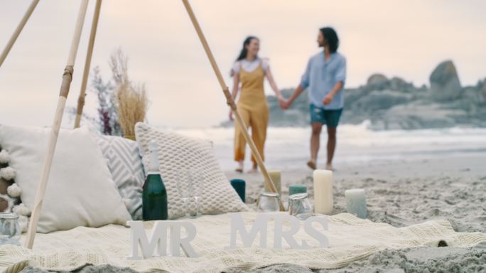 一对幸福的年轻夫妇求婚后在海滩上散步。一对相爱的男女，庆祝他们的订婚