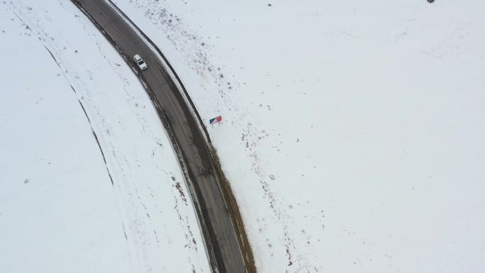 航拍汽车行驶在冰天雪地的川藏公路上