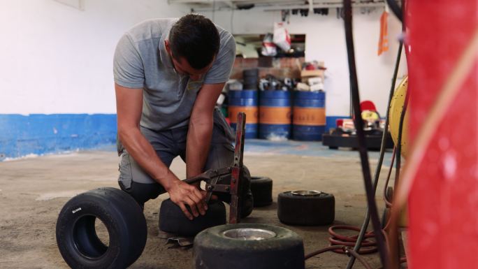 男技工在修理厂更换手推车的瘪胎