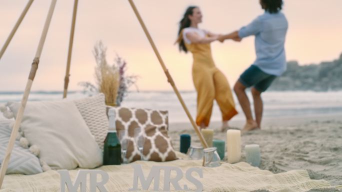 一对幸福的年轻夫妇在求婚后在海滩上跳舞和玩耍。一对相爱的男女，庆祝他们的订婚