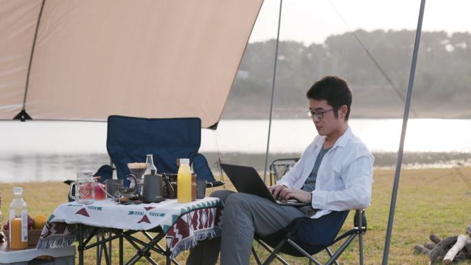 4K年轻男性户外露营使用笔记本办公