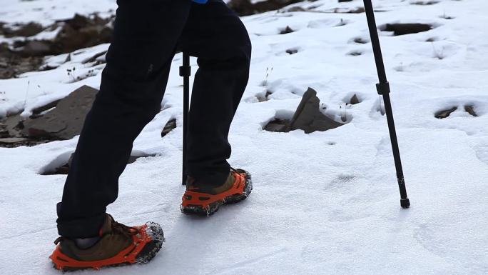 爬雪山 男子穿冲锋衣爬雪山 拄拐棍爬雪山