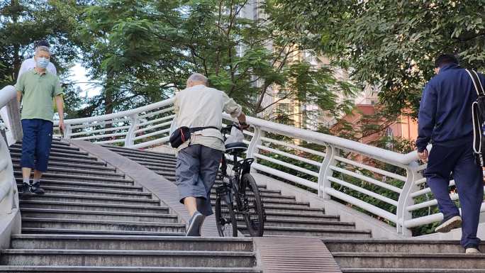 一个老人推自行车上天桥