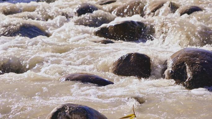 湍急的小河流水冲刷河中的石头