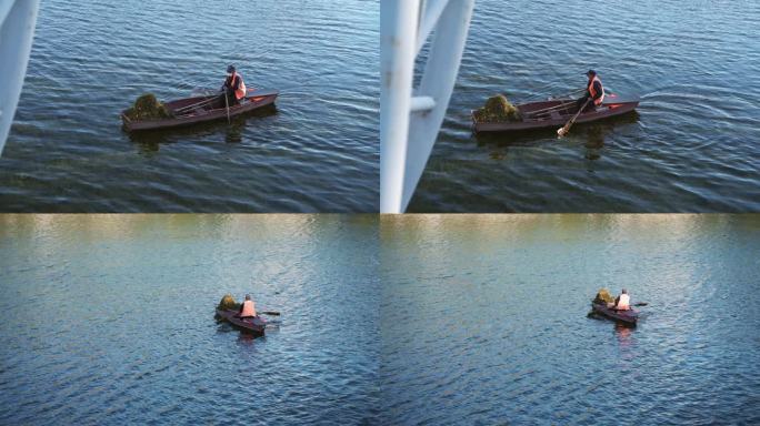 河面上划船打捞水草的环卫工人