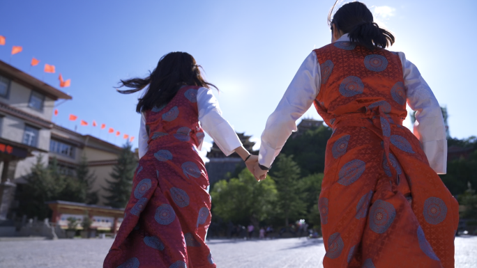 在阳光下奔跑的两个少数民族藏族女孩