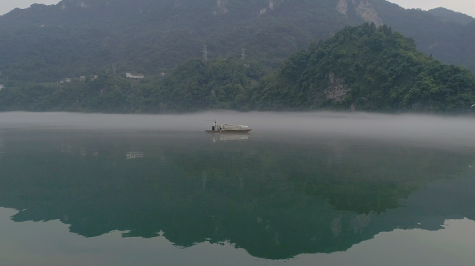 晨雾水面划着小船4K航拍