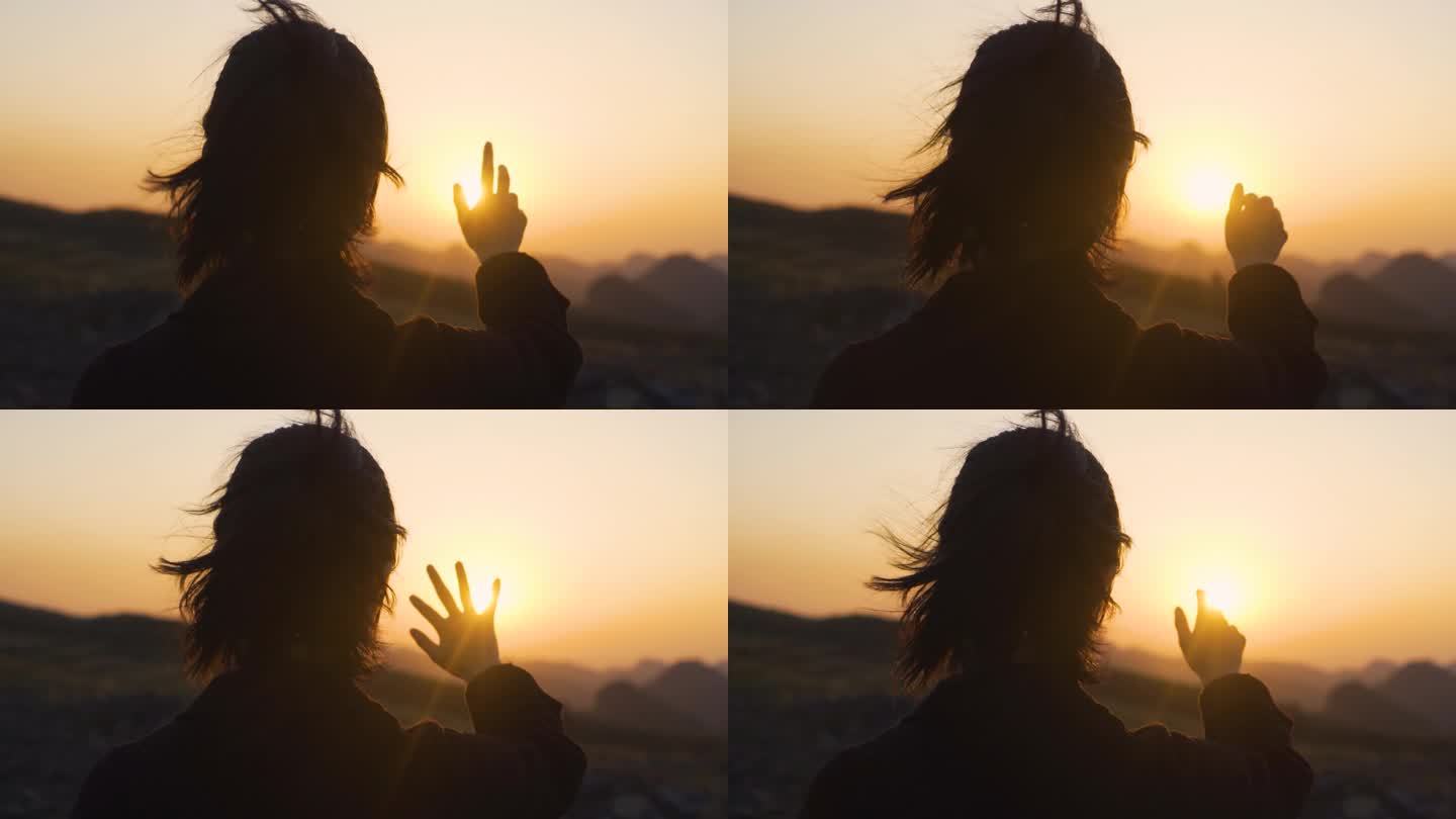 唯美女生山顶眺望夕阳伸手触摸阳光风吹发丝