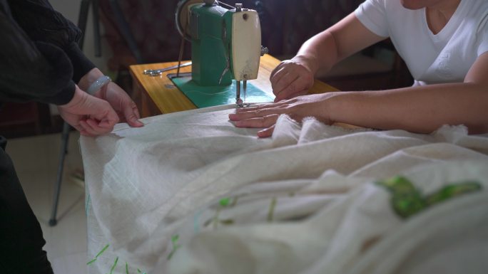 一位裁缝在使用传统缝纫机缝制窗帘