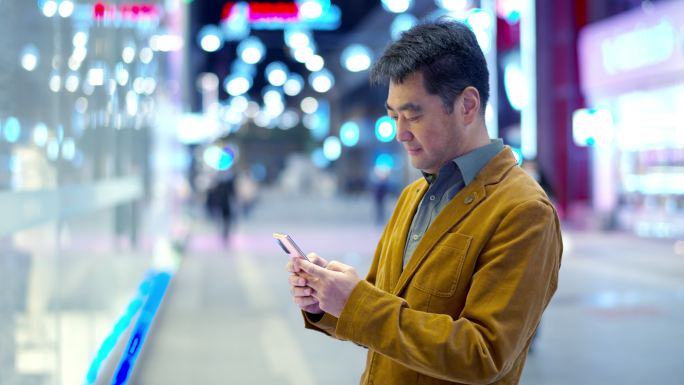 4K 帅气男人使用智能手机在夜晚的街道