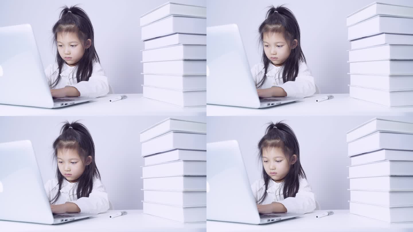 在书桌上使用笔记本电脑的小女孩