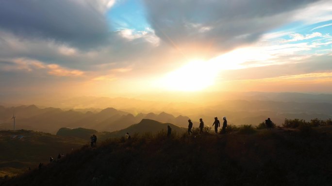 戴头盔的摩托车骑士在夕阳中攀登山峰