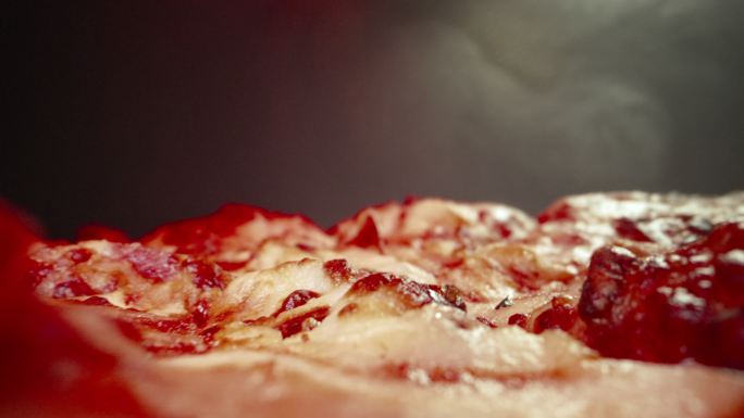 超特写广角微距拍摄的奶酪在美味的蒸热深盘辣椒香肠披萨上，新鲜出炉，放在加热灯下的冷却架上，手推车相机