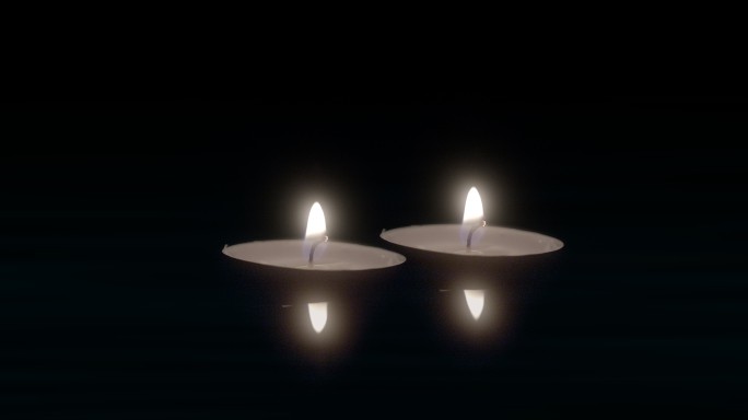漂浮在水面上的两根蜡烛在黑暗中燃烧。