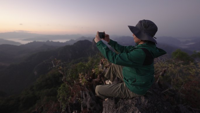 女人在山顶徒步旅行，双手放在头上庆祝成功