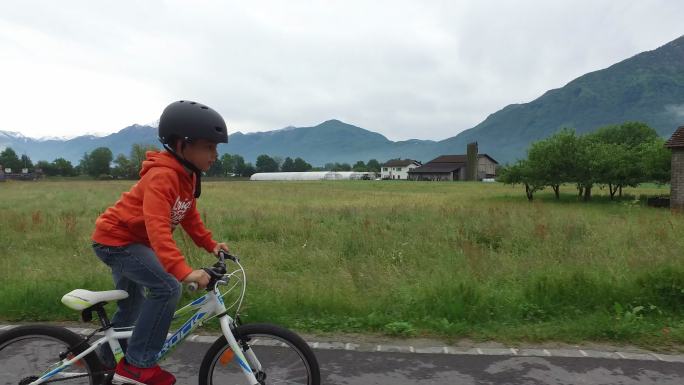 以下是一个小男孩在农村骑自行车的照片