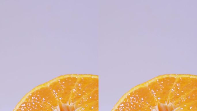 橙汁倒落在切开的丑橘上，碰撞飞溅水花。
