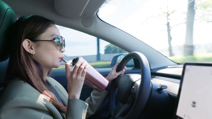 亚洲女性驾驶汽车美女时尚喝咖啡开心开车