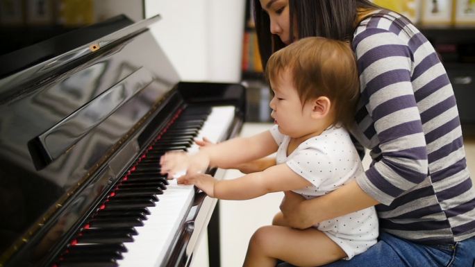 马瑟和小男孩在家里弹钢琴，一家人共度时光的概念