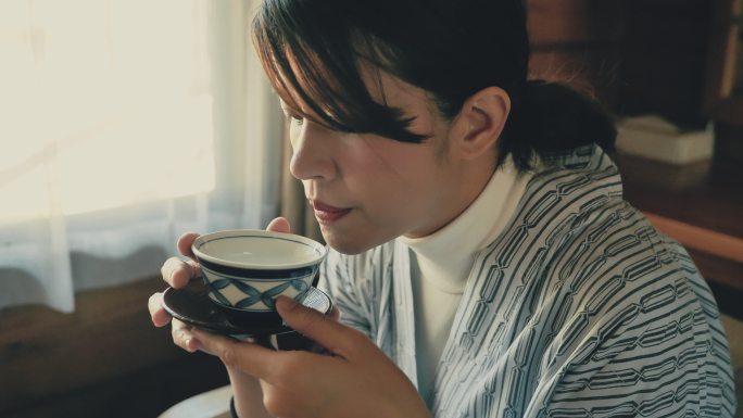 年轻的亚洲女人啜饮热茶仪式