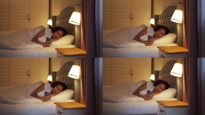 一个女人躺在床上，静静地用手机发短信