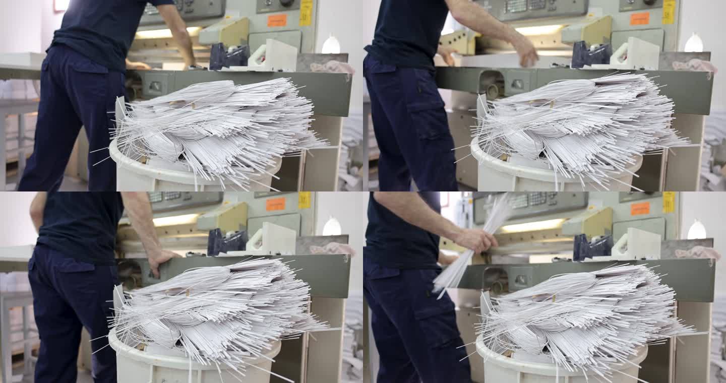 无法识别的工人在印刷厂，在CNC切割机上切割纸张束