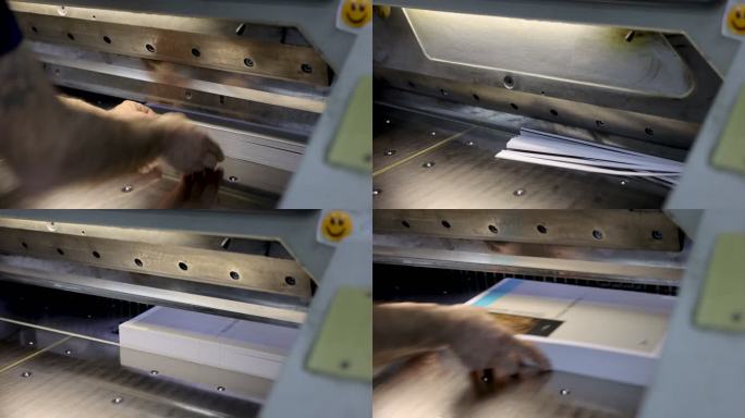 B-在印刷厂里的无法辨认的工人卷起，在CNC切割机上切割一束纸