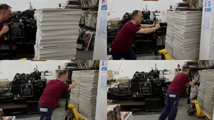 强壮的白人工人使用手动叉车运输打印和堆叠的介质