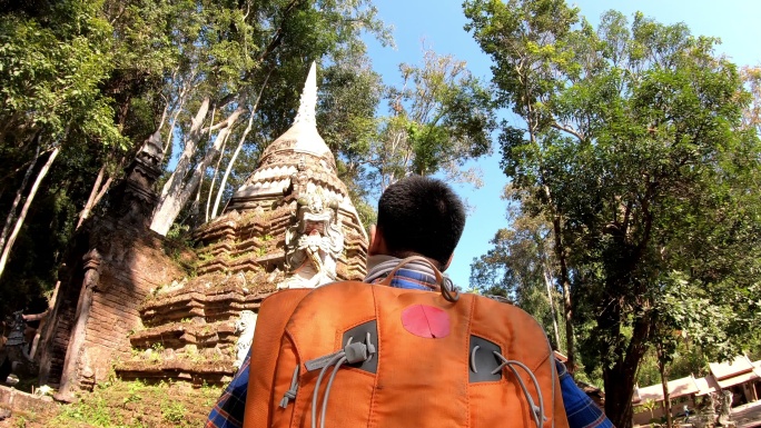 一位亚洲游客背着背包走进寺庙
