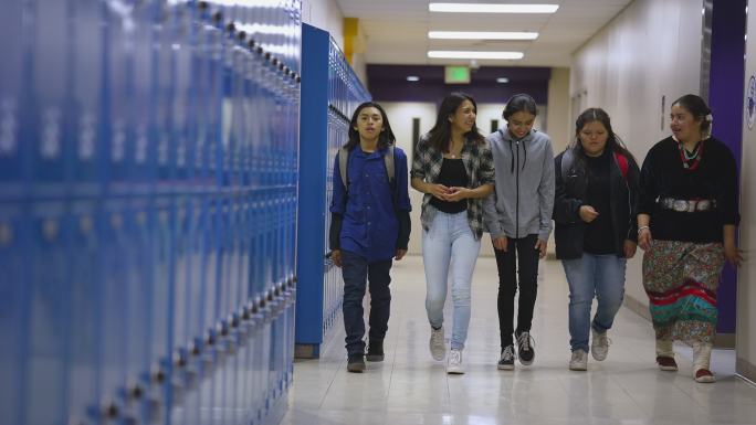 一群高中生穿过学校走廊