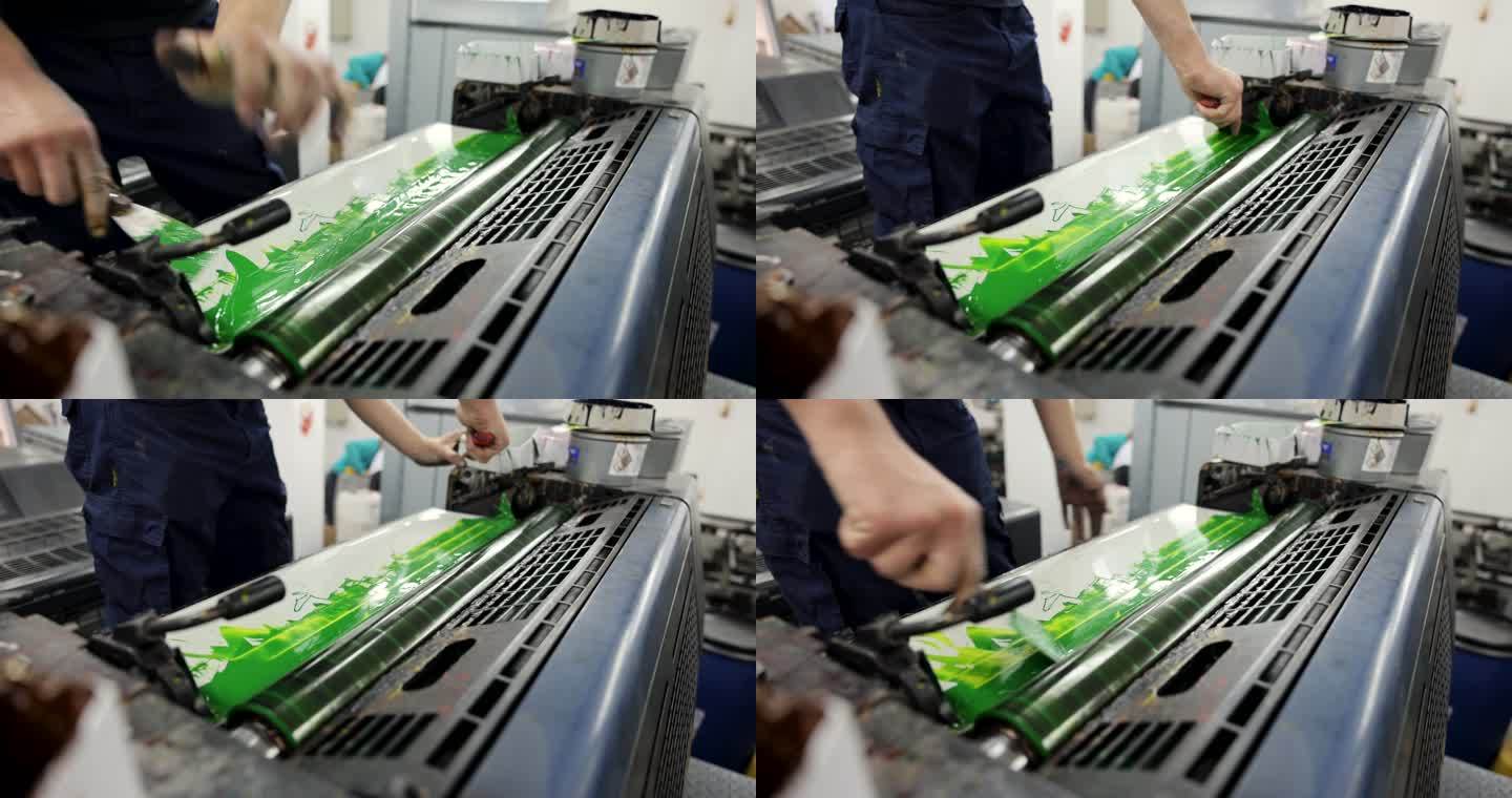 白人工人，在印刷机上涂上绿色