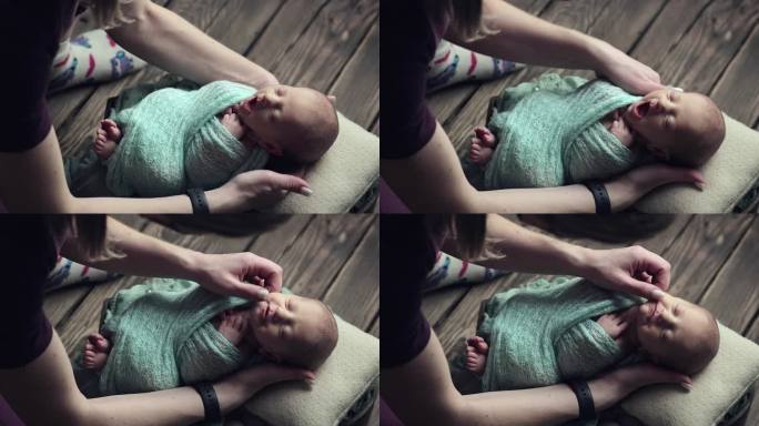 摄影师在拍照时照顾婴儿。婴儿在拍照时打呵欠，想睡觉。