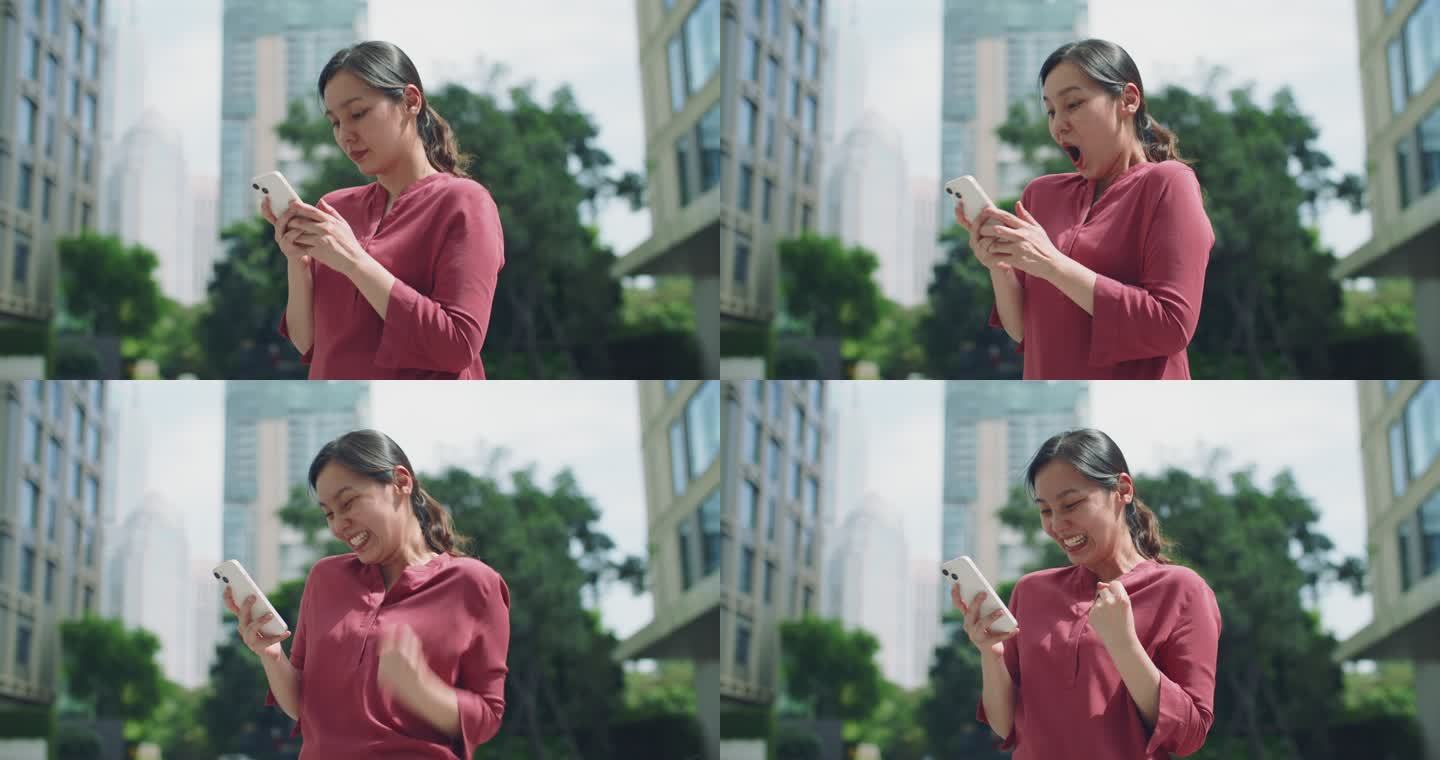兴奋的亚洲女人庆祝检查手机