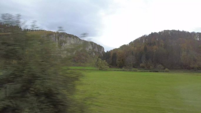 火车行驶过绿色的草原森林与山脉