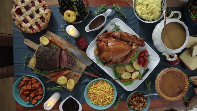 感恩节用烤牛肉、蔬菜、汤、南瓜、浆果馅饼和各种奶酪填充火鸡