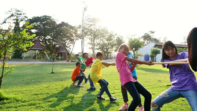 一群学龄前儿童在公园里拔河。户外游戏，童年，友谊，领导，儿童节。