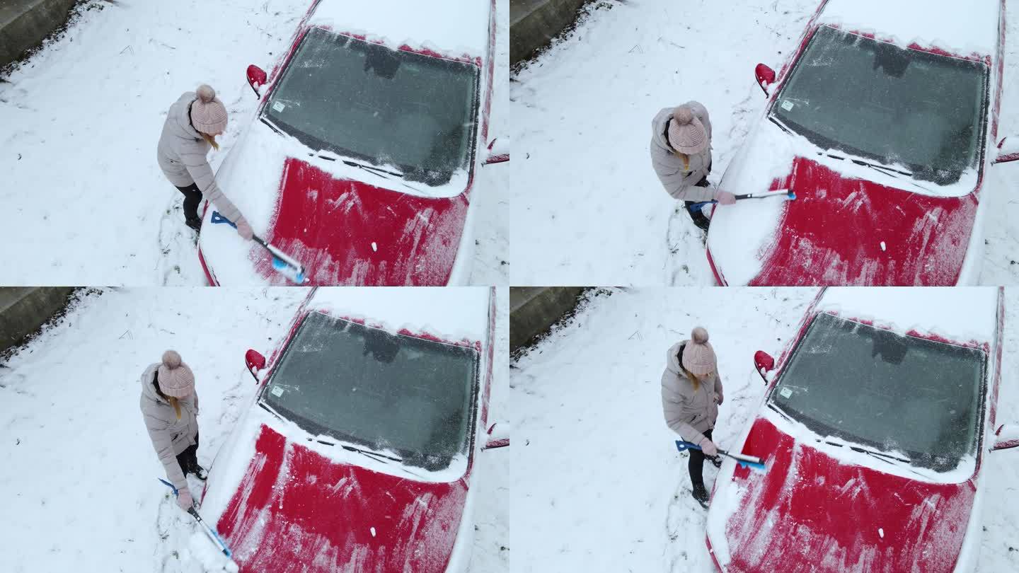 女人从车上除雪立冬小雪大雪冬至汽车上积雪