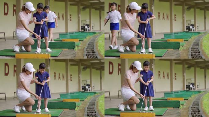 亚裔中国高尔夫母亲在练习场高尔夫球场教女儿打高尔夫球