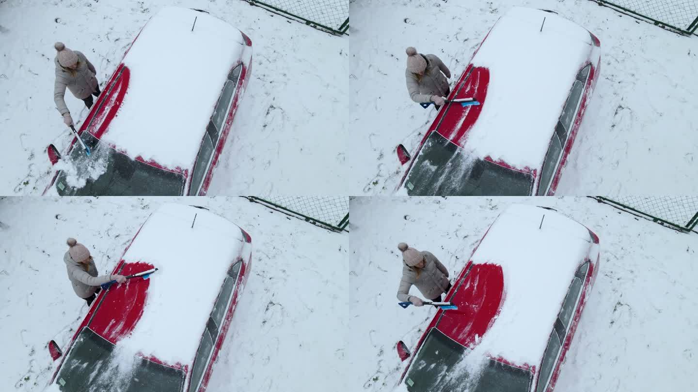 一名妇女正在清理车顶上的积雪