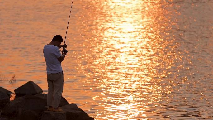 夕阳下河边钓鱼的人