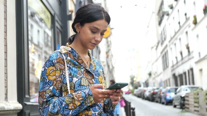 美丽时尚的女人在老城区，使用智能手机-蒙马特，巴黎
