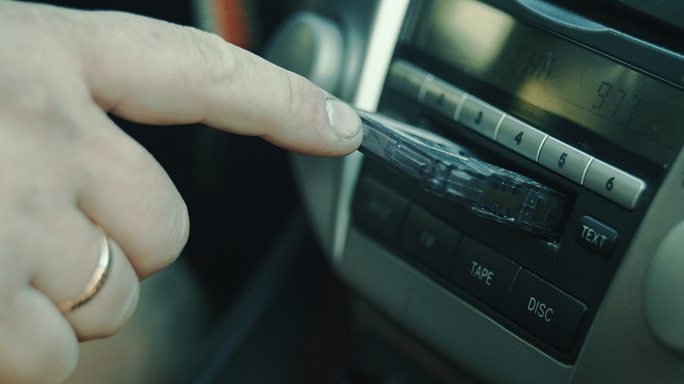 打开车里的盒式磁带播放机。