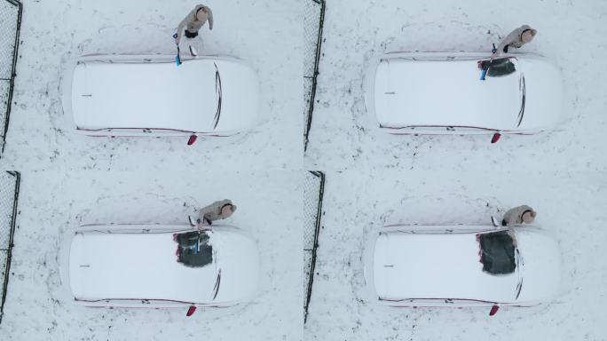 鸟瞰图，一名妇女正在清理车上的积雪