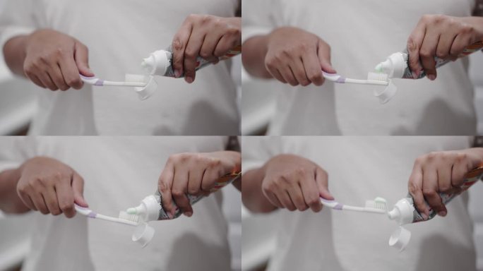 女人用手在牙刷上涂牙膏