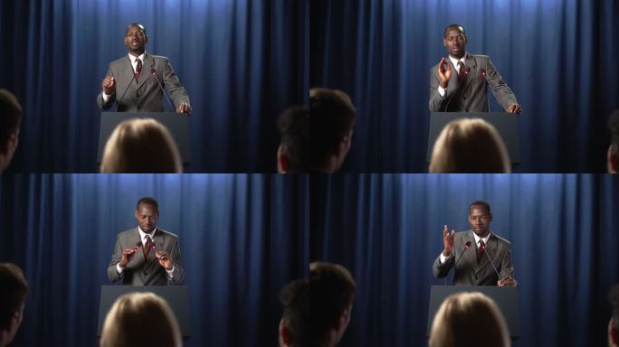 一位非裔美国政治家在辩论中发表演讲，听众为他鼓掌