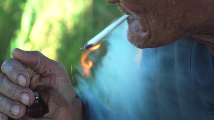 吸烟的老人吸烟的老人皮肤黝黑劳累