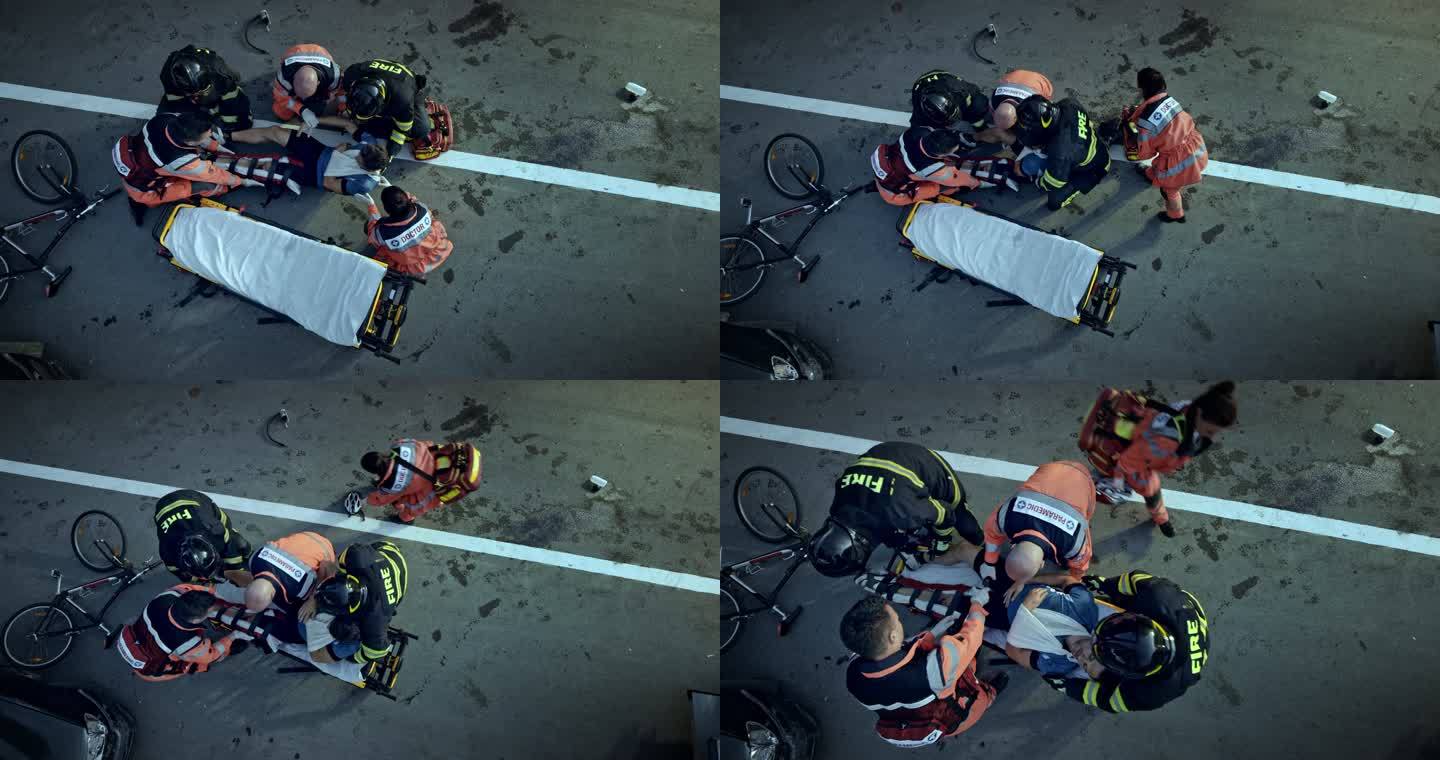 CS医护人员和消防员在事故现场将一名受伤的男性骑车人抬上担架