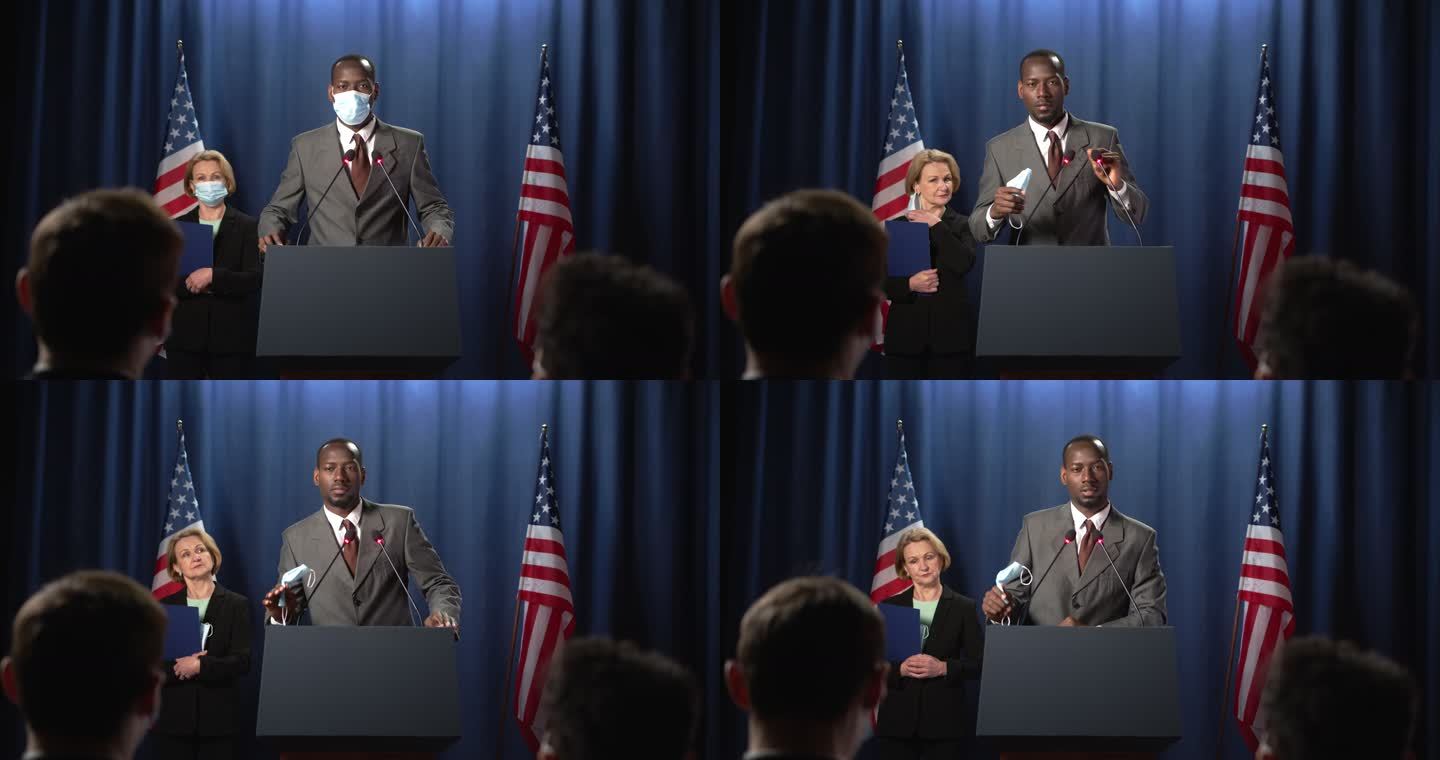 非裔美国政治家和戴着面具的新闻秘书进入画面，摘下面具，政客在辩论中开始演讲