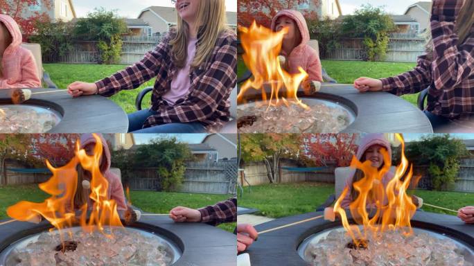两个女孩和她们的妈妈坐在后院的篝火旁烤棉花糖