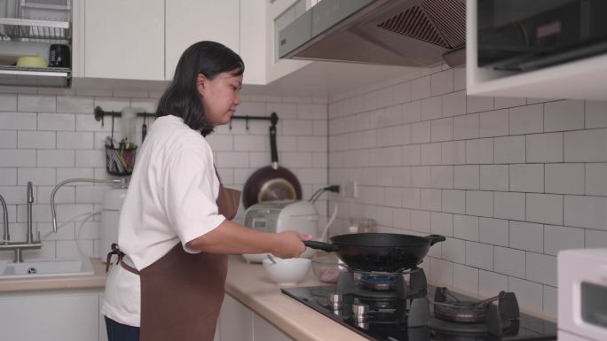 女人打开煤气炉准备做饭